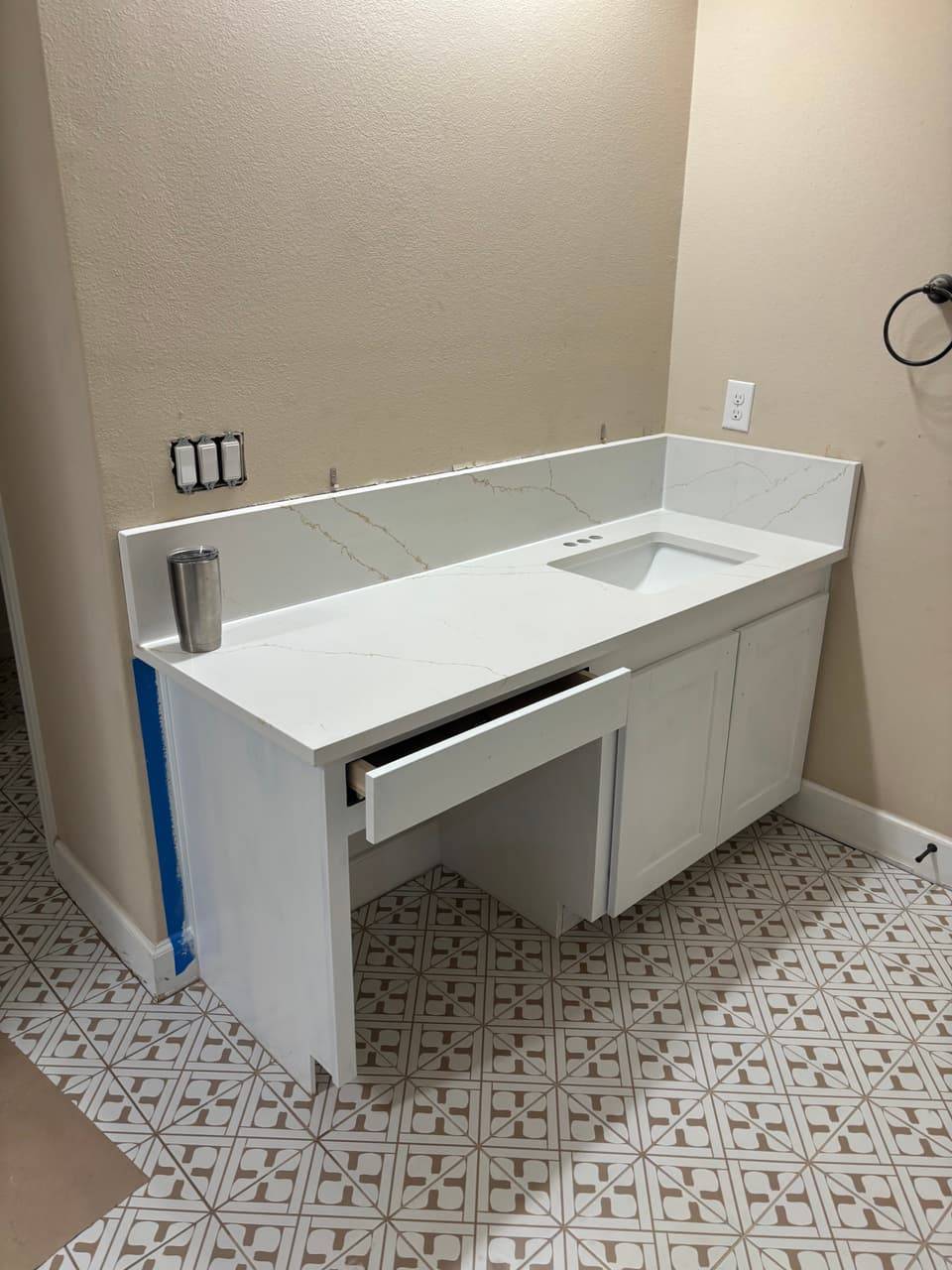 White bathroom vanity with a quartz top, undermount sink and an open drawer
